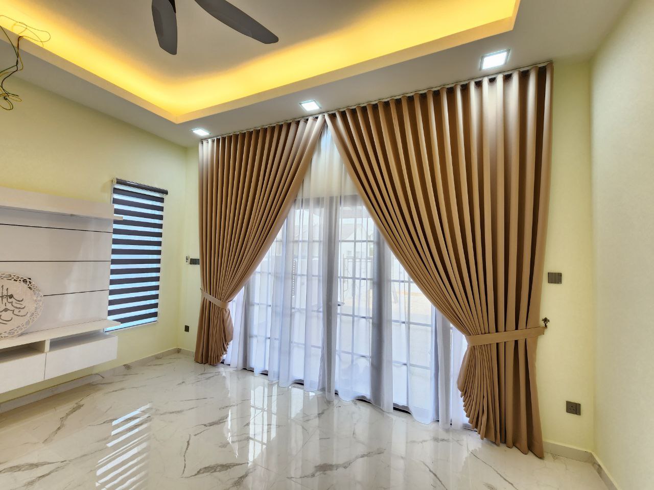 A small, modern living room with light-colored curtains